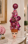 A decorative 18 inch Christmas tree or table top tree, decorated with pink and purple ornaments, flowers, and baubles, displayed on a vintage Barbie Doll 3D ceramic mug, perfect for your entry way!